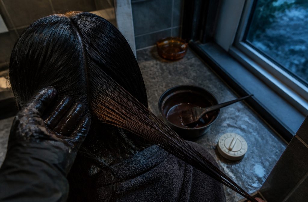 Black hair with one finished colored section beside the untouched dark lengths