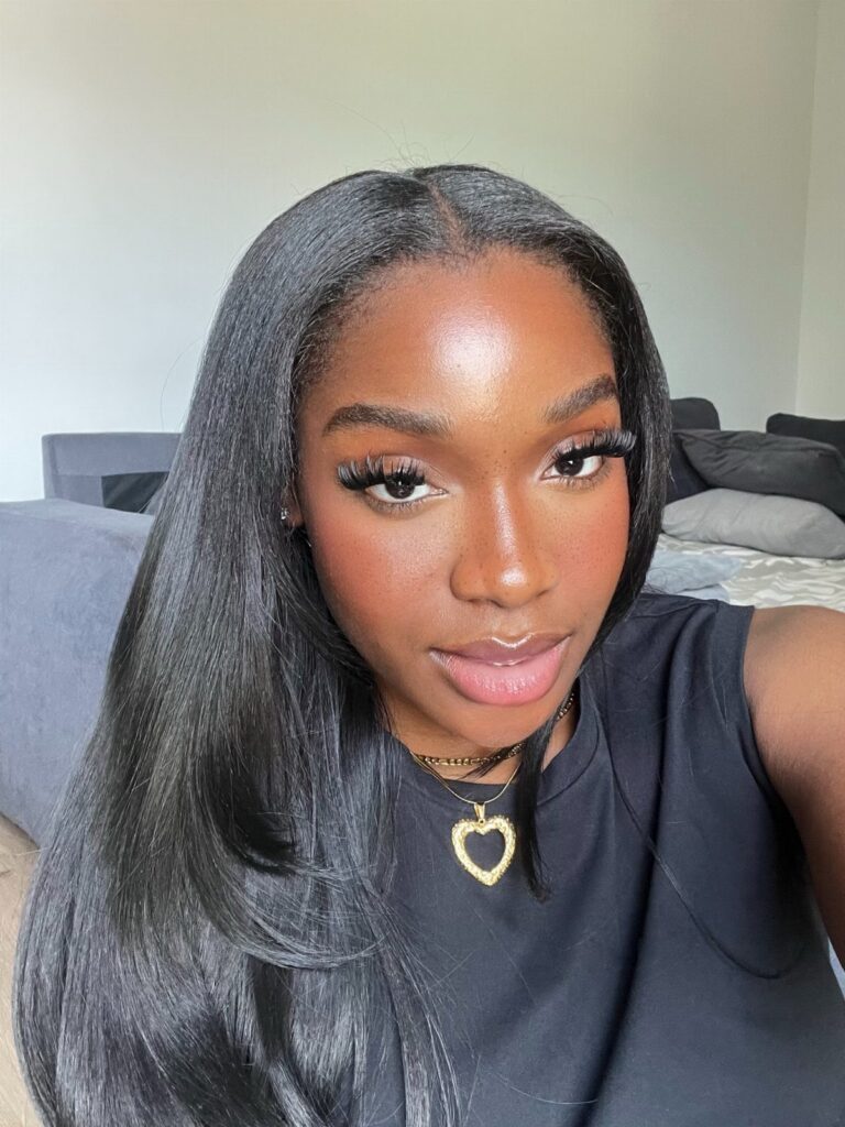Woman showcasing sleek, long jet-black hair with a center part
